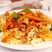 Makaron z sosem pomidorowym, kurczakiem i mini marcheweczkami