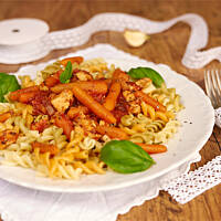 Makaron z sosem pomidorowym, kurczakiem i mini marcheweczkami