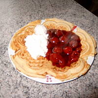 Wafel z goracymi wisniami i bita smietana