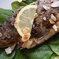 Pstrąg z nadzieniem z wędzonego sera, liściami szpinaku i migdałami