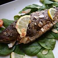 Pstrąg z nadzieniem z wędzonego sera, liściami szpinaku i migdałami