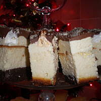 sernik na biszkopcie z bezami i polewą .