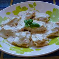 Ravioli pieczarkowe w sosie serowym z szynką i cebulą