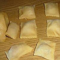 Ravioli pieczarkowe w sosie serowym z szynką i cebulą