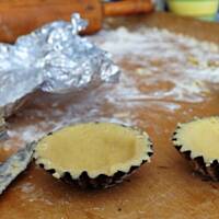 Kruche babeczki z budyniem i owocami z pomarańczową glazurą