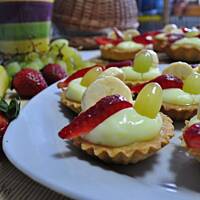 Kruche babeczki z budyniem i owocami z pomarańczową glazurą