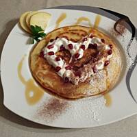 Pancakes z bitą śmietaną, granatem i syropem klonowym