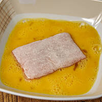 Po opanierowaniu mąką zanurzamy paczuszki w jajku rozbełtanym z niewielką ilością mleka.