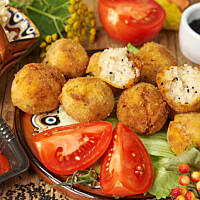 Ryżulki możesz przyrządzić w wersji z szynką lub w wersji wege - z posiekanymi drobno oliwkami. Obie świetnie komponują się z pomidorowym sosem, cząstkami pomidorów lub surówką. Pasuje też do nich słodko-kwaśny sos do sajgonek.